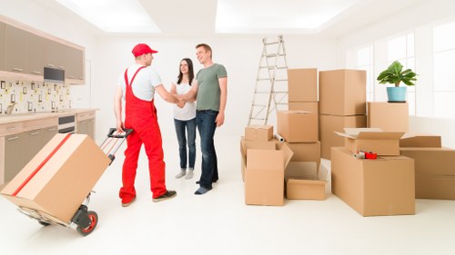 Local moving helper carrying boxes for a Beddington customer